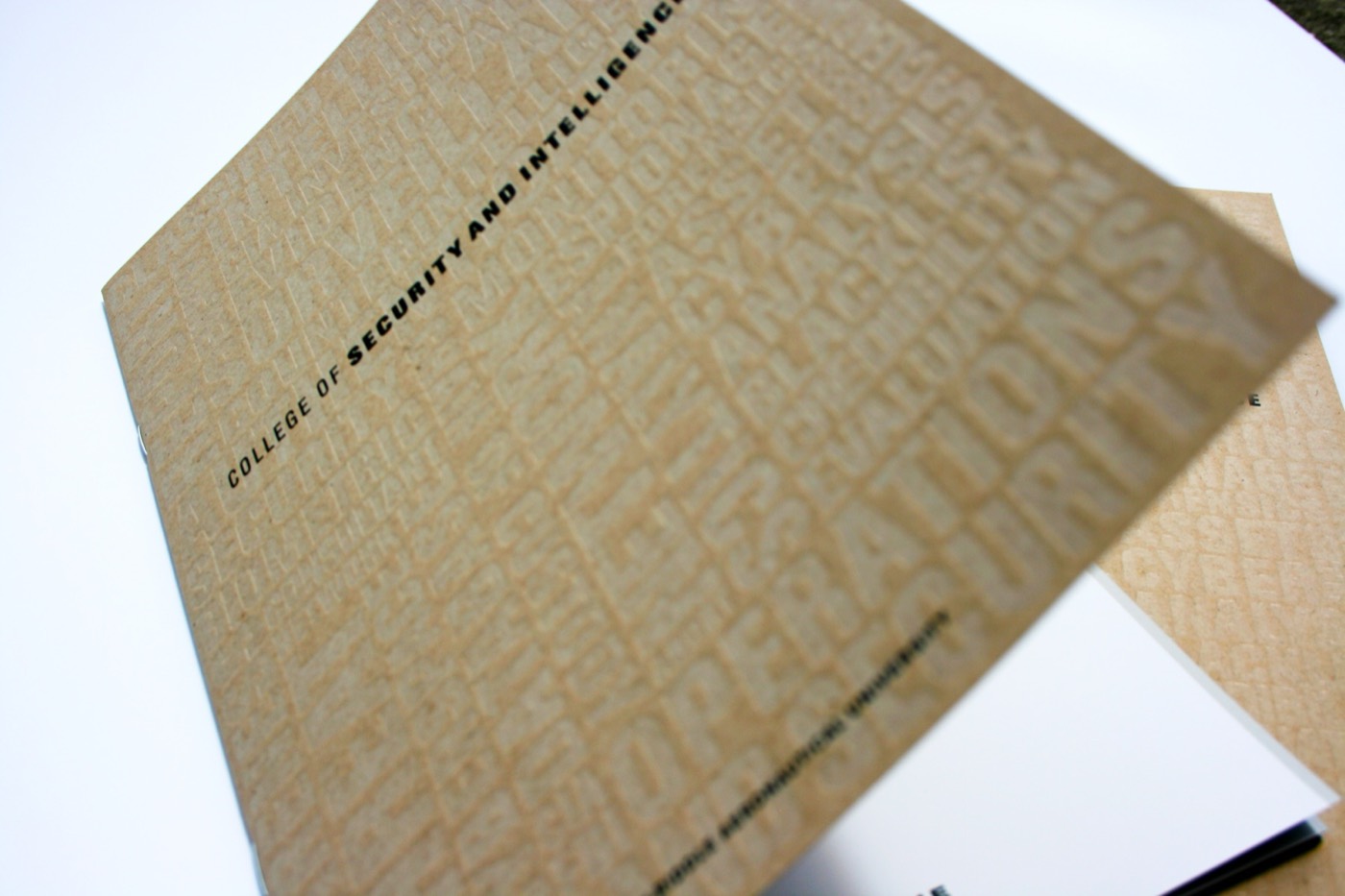 A close crop of a blind emboss on kraft stock