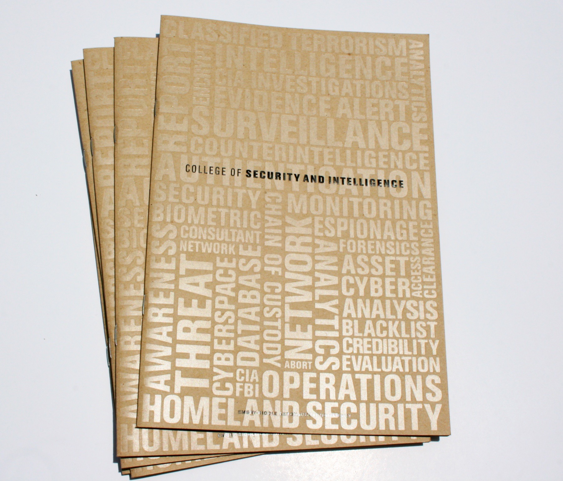 A fanned stack of kraft covers with a blind embossed word cloud