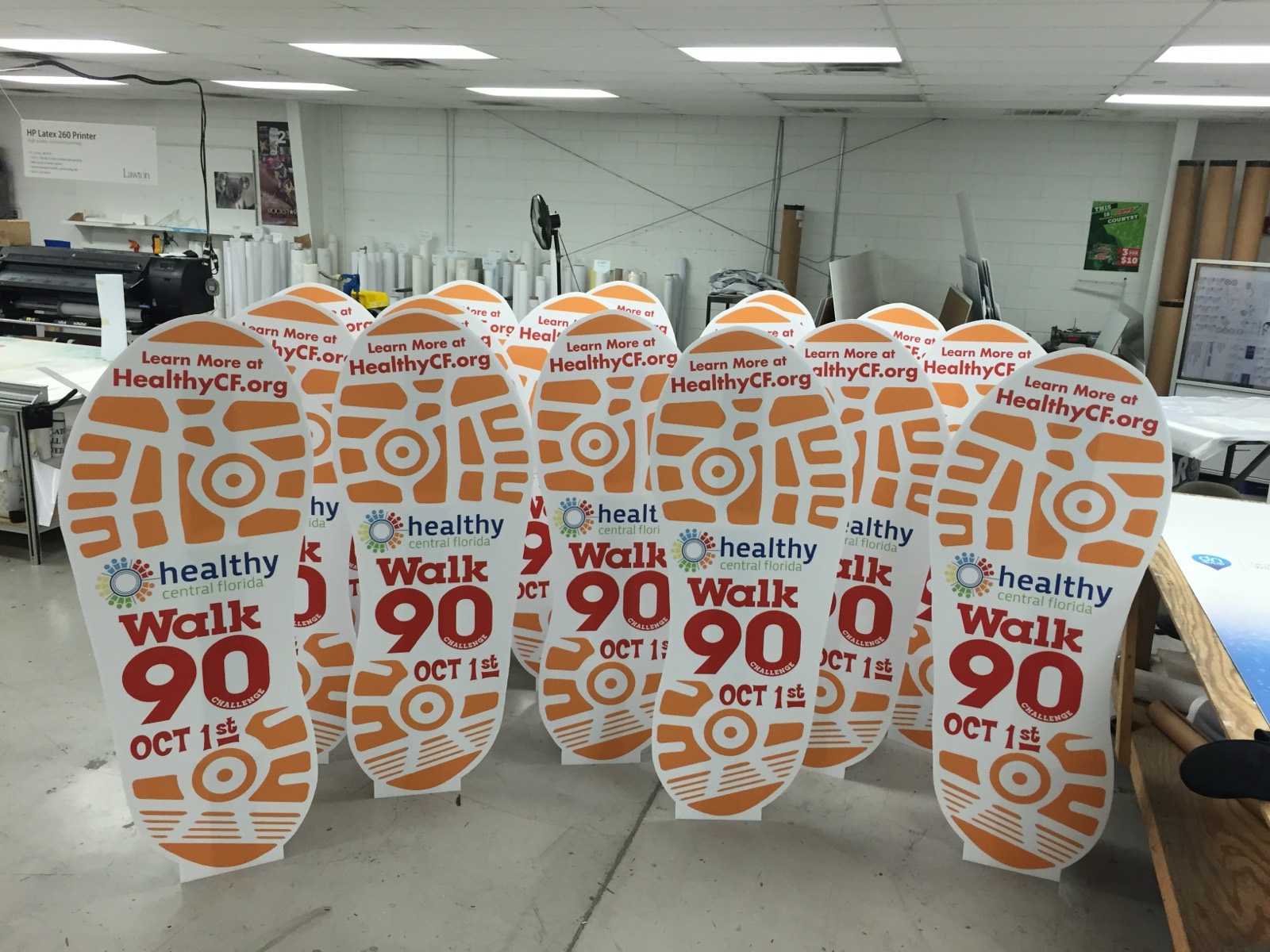 Die-cut footprint signs for a Healthy Central Florida walk, lined up on the plant floor