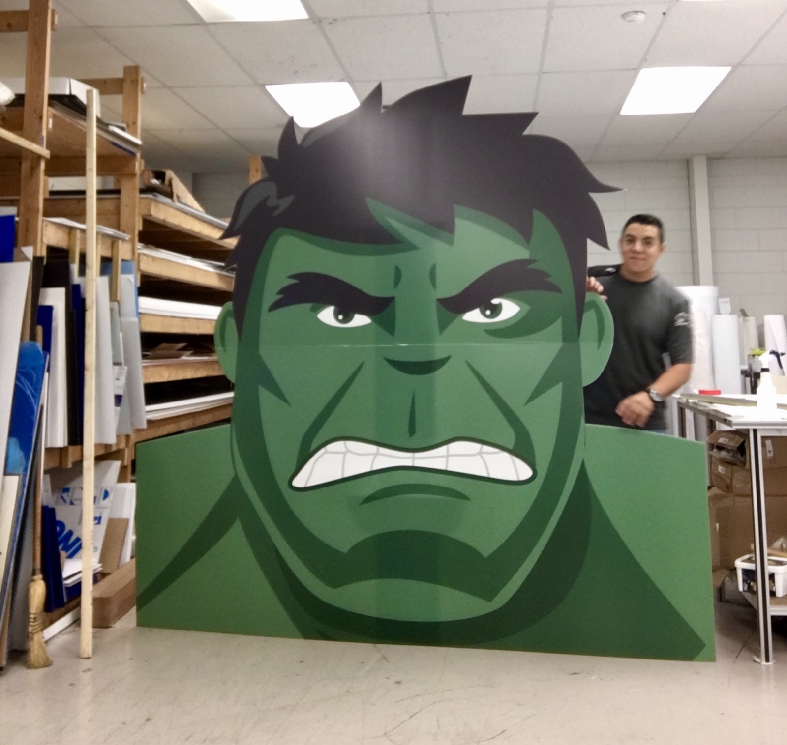 A large die-cut Hulk standee on the plant floor, shown with a person behind it for scale