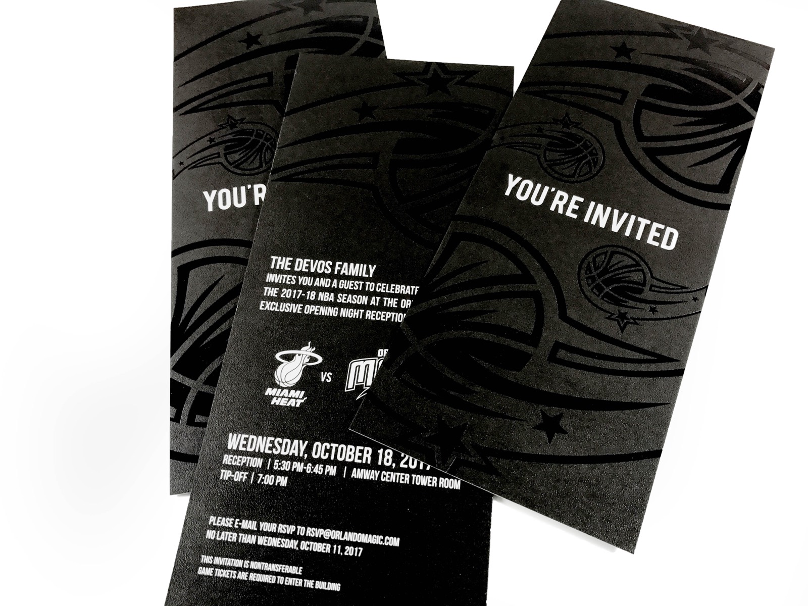 Black invitation mailers with white type