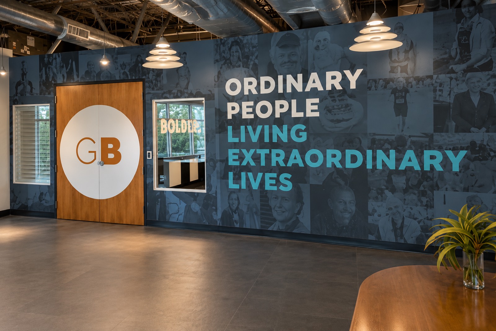 A full-wall photo collage mural reading Ordinary People Living Extraordinary Lives